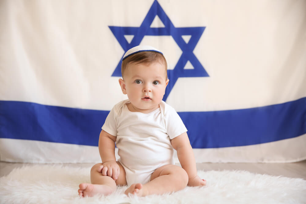 Jewish baby boy in front of a flag of Israel