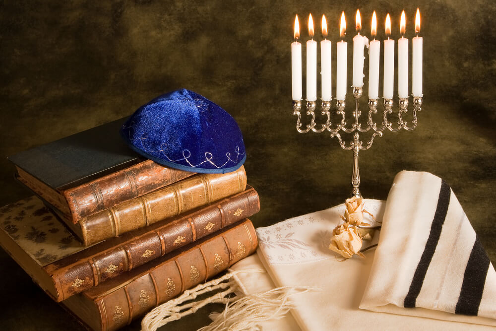 Jewish religion books, menorah and a fine tablecloth on a table