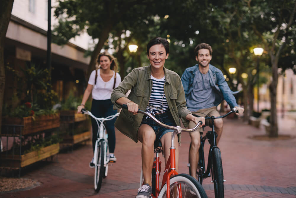 Three young people cycling down the street