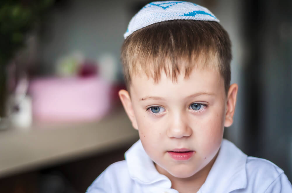 A Kid With a Traditional Jewish Kippah Cap on His Head