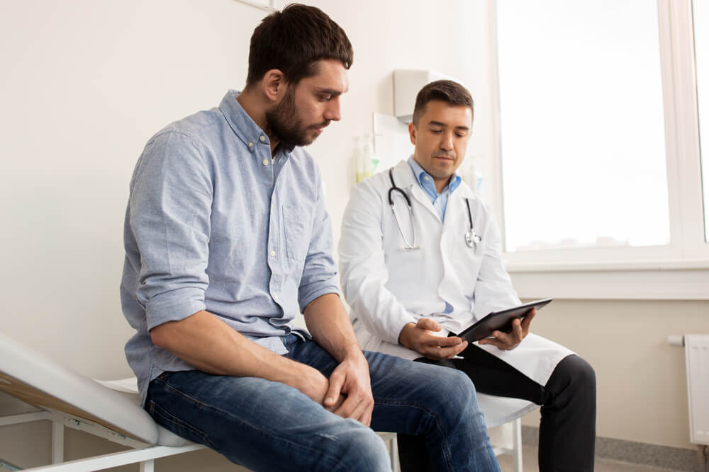 Medicine Healthcare and People Concept Doctor With Clipboard and Young Male Patient Having Health Problem Meeting at Hospital