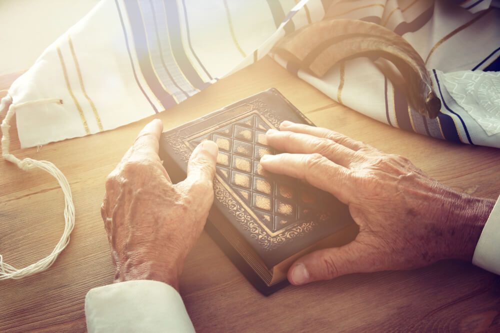 Old Jewish Man Hands Holding a Prayer Book